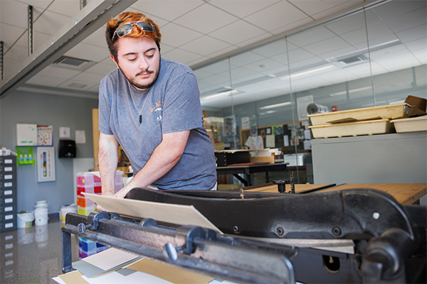 MCLA art student at a machine